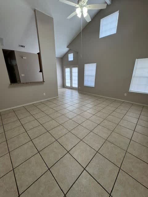 A room with a ceiling fan and tile flooring.