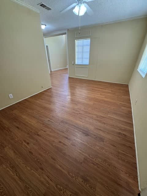 A room with wooden flooring and a ceiling fan.
