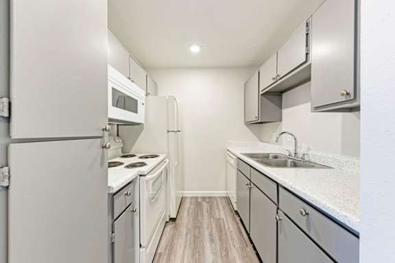 A kitchen with white appliances and cabinets.