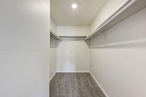 A long, narrow hallway with a carpeted floor and white walls.