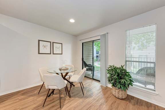 A dining room with a glass table and chairs.