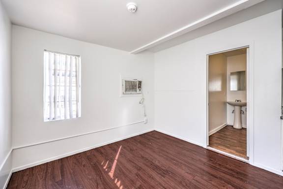 A room with a wooden floor and a window.