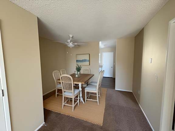 A dining room with a table and chairs.