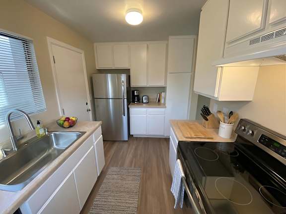A kitchen with white cabinets and a black stove top oven.