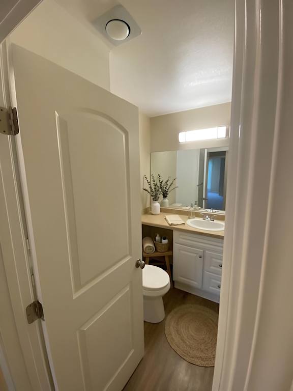 A white bathroom with a toilet, sink, and mirror.