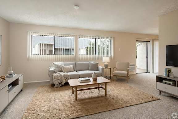 A living room with a grey couch and a wooden coffee table.
