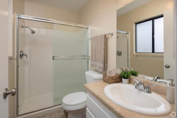 A bathroom with a toilet, sink, and shower.