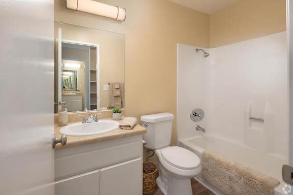 A bathroom with a white toilet, sink, and bathtub.
