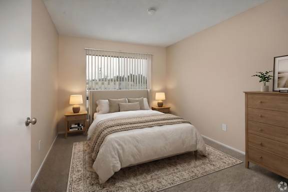 A bedroom with a large bed and two lamps.