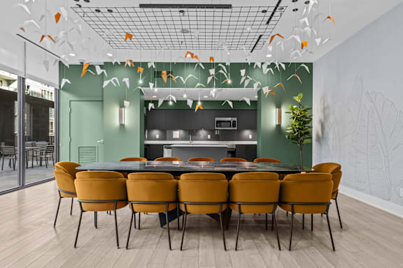 A dining room with a table surrounded by chairs.