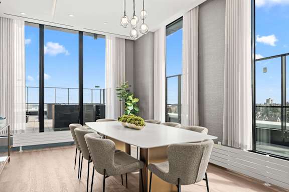 A dining room with a table and chairs with a view of the outside.