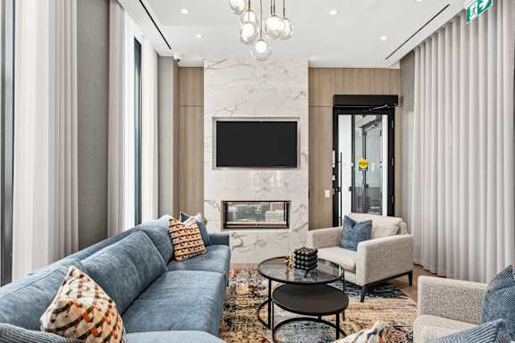 A modern living room with a grey sofa, a black coffee table, and a fireplace.