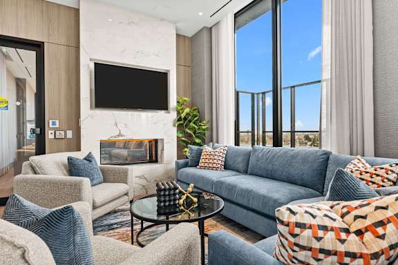 A living room with a fireplace and a flat screen TV mounted on the wall.