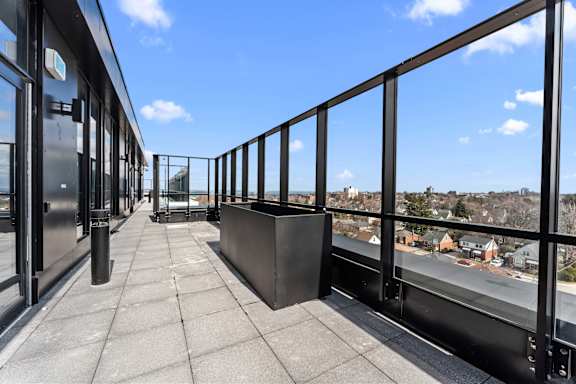 A balcony with a metal railing and a view of a residential area.