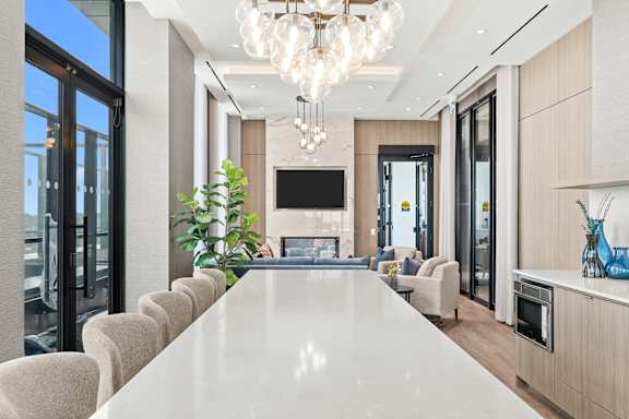 A modern dining room with a long table and chairs.