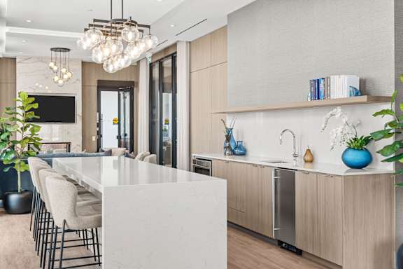 A modern kitchen with a white island and wooden cabinets.