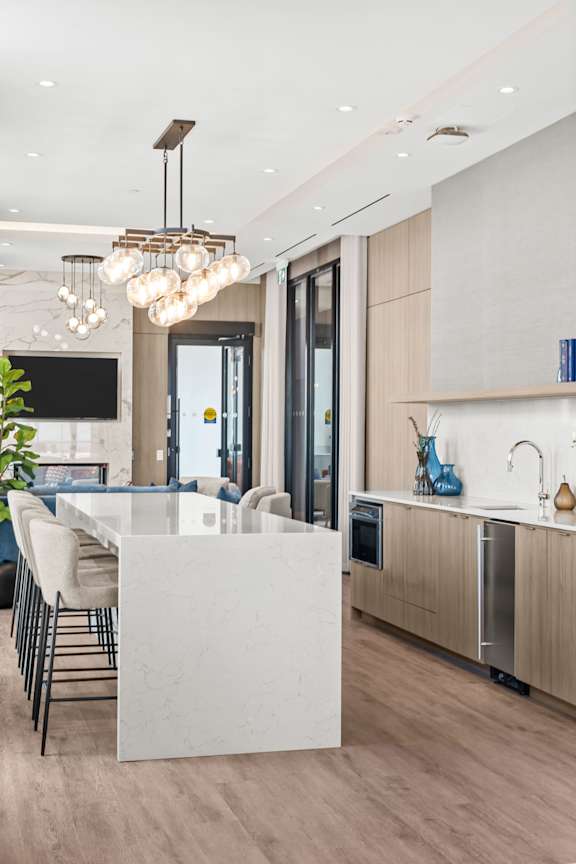 A modern kitchen with a white island and wooden cabinets.