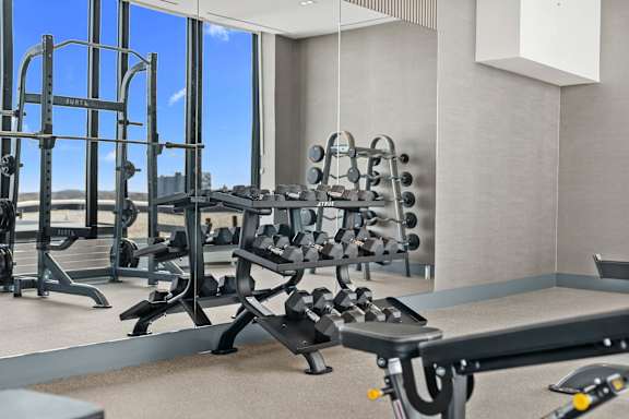 A gym with a view of the city outside the window.