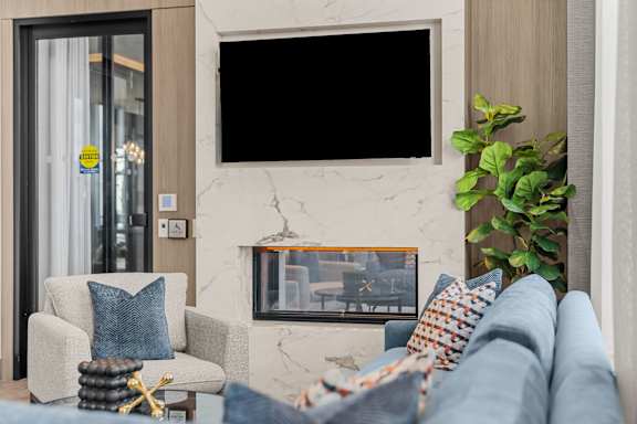 A living room with a couch, chair, and a fireplace.