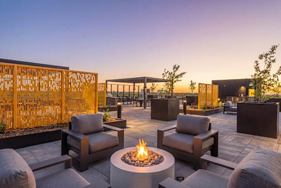 A patio with a fire pit and seating area.