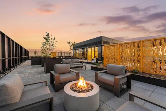 A patio with a fire pit and seating area.