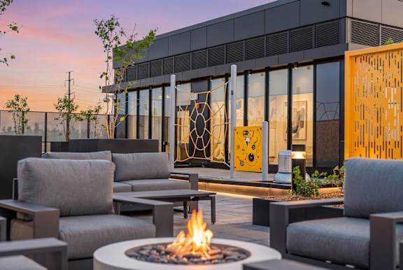 A modern outdoor seating area with a fire pit in the center.