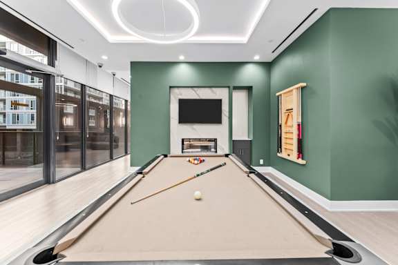 A pool table with a white ball and two cues in the middle of the table.