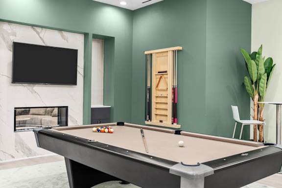 A pool table with a white ball and a cue stick on it.