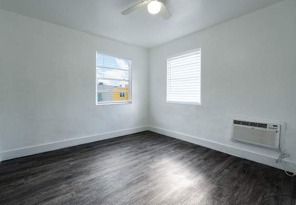 A room with a window and a fan on the ceiling.