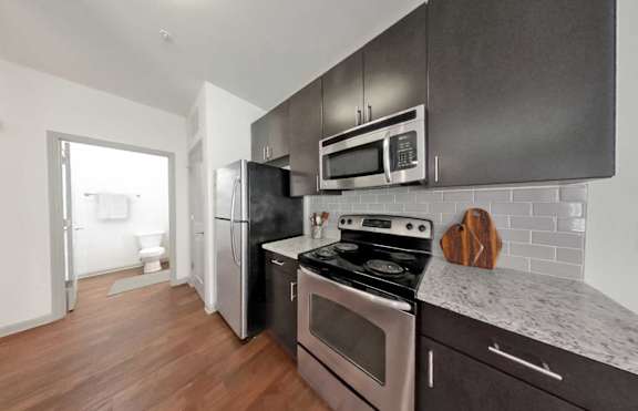 A kitchen with a stove, oven, refrigerator, and microwave.