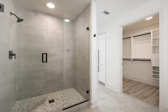 Frameless walk-in showers with stone flooring