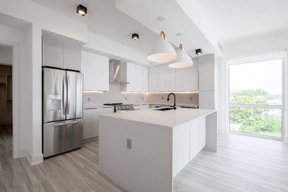 A modern kitchen with a white island and stainless steel appliances.