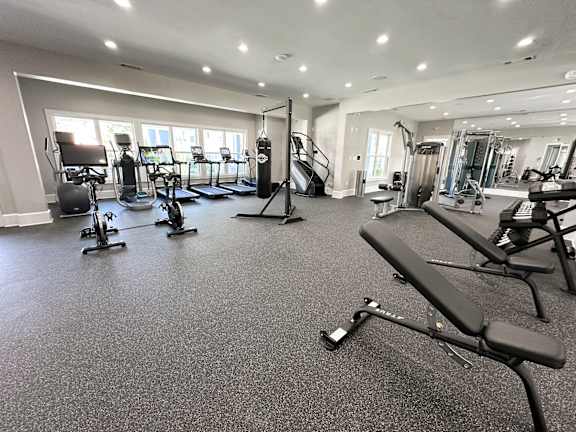 A spacious gym with a variety of equipment including treadmills, stationary bikes, and weight machines.