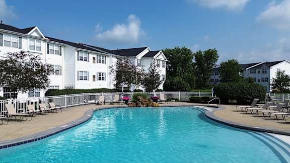 A swimming pool in front of apartment buildings.
