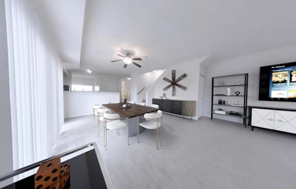 A modern living room with a dining area and a television.