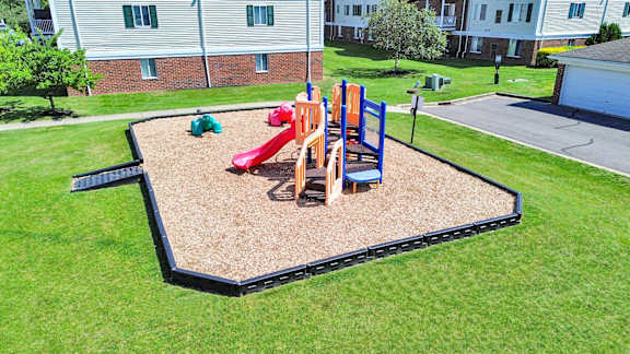 A playground with a red slide and a blue slide.