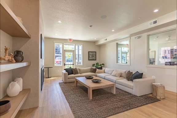 A living room with a couch, coffee table, and a television.