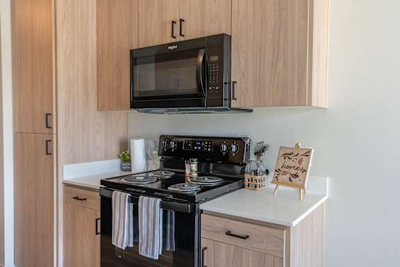 A kitchen with a stove, microwave, and oven.