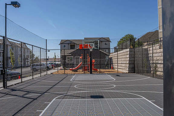 A basketball court with a red slide in the middle of it.