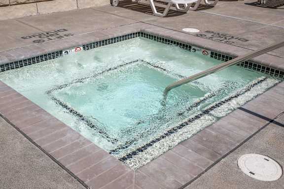 A pool with a metal rake in it.