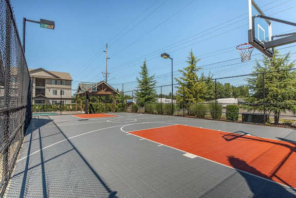 A basketball court with a red area in the middle and a basketball hoop on the right side.