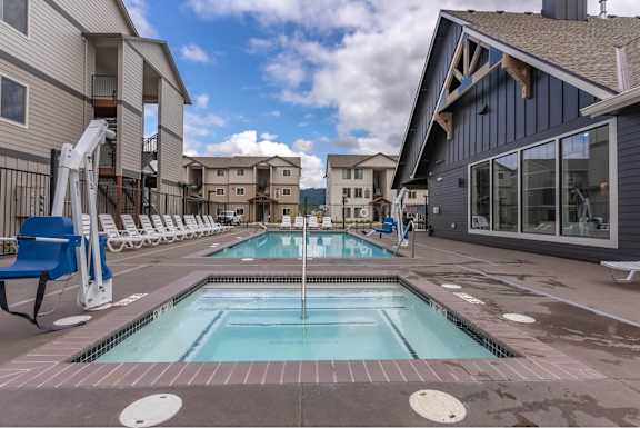 A swimming pool in a residential area with a blue chair and a white ladder.