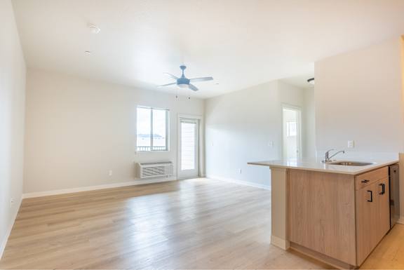 A kitchen with a wooden counter and a fan on the ceiling.