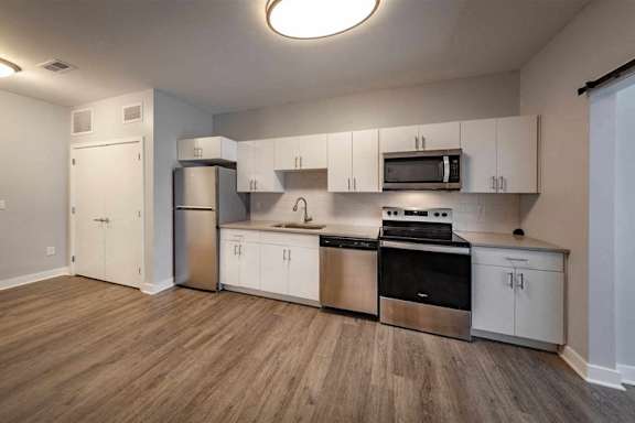 A kitchen with white cabinets and stainless steel appliances.