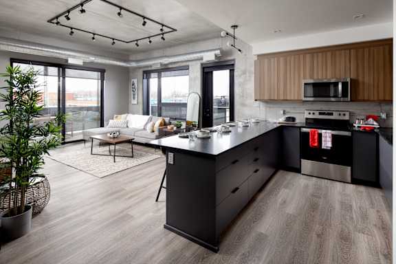 A modern kitchen with a large island and a dining area.at Damask, Ontario
