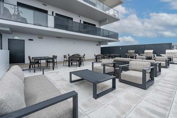 A patio with a table and chairs is in front of a white building at Damask, Windsor, ON N8S 0B7