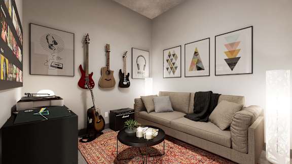 A living room with a couch, a coffee table, and a wall with framed pictures and guitars at Damask, Windsor, ON