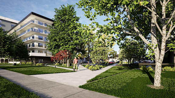 A man is walking his dog in a park with a large building in the background at Damask, Ontario, N8S 0B7
