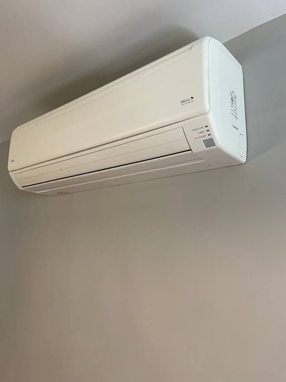 A white air conditioner unit mounted on a wall.