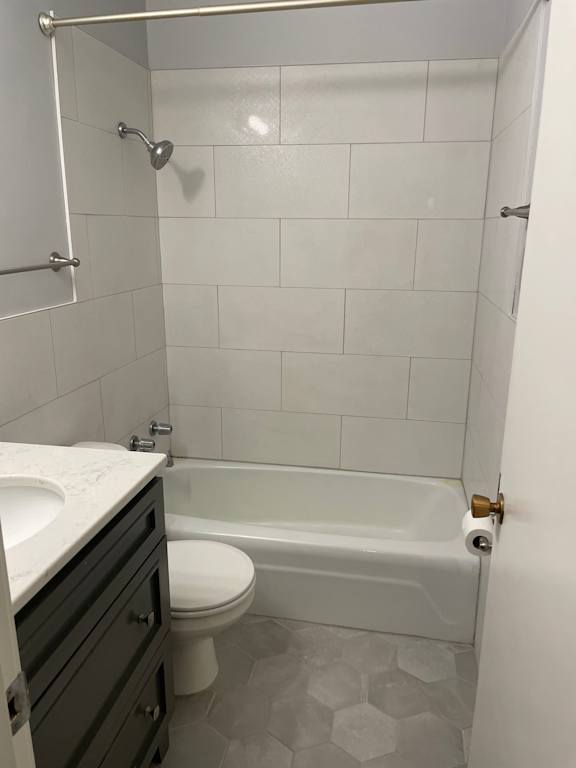 A white toilet sits next to a white bathtub in a bathroom.